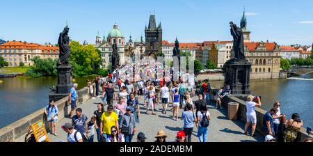 Foule sur le Pont Charles, Karluv Most, derrière l'église de la Sainte Croix avec tour du pont de la Vieille Ville, Prague, République Tchèque, République Tchèque Banque D'Images