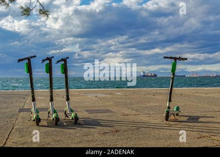 Garé vert et noir le covoiturage La Chaux-S electric scooters sans passager à bord de l'eau à côté de la mer à Thessalonique, en Grèce. Banque D'Images