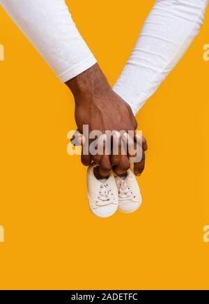 Mains de black couple holding baby boots ensemble Banque D'Images