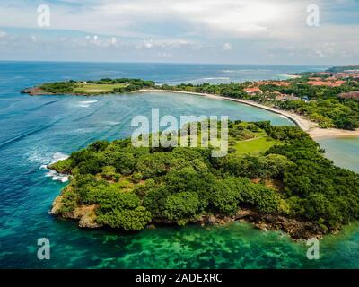 Plage de Nusa Dua à Bali Indonésie vus du dessus au cours de l'été d'après-midi avec drone survolant la région de la baie dans le pic de la saison touristique Banque D'Images