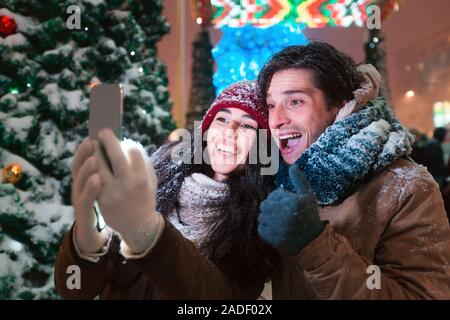 Couple debout à côté d'Selfies Arbre de Noël dans la ville Banque D'Images