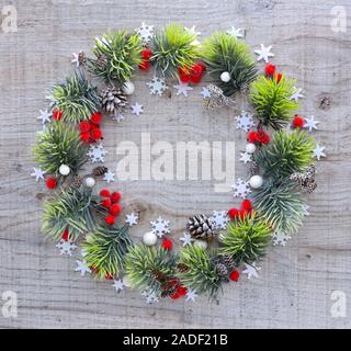 Noël ou Nouvel an composition. Cadre rond faits de branches d'épinette et de décorations de Noël sur fond de bois. Maison de vacances et de fête concept Banque D'Images