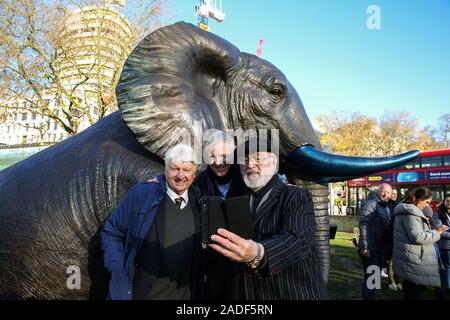 Marble Arch. London, UK 4 Déc 2019 -auteur et père du premier ministre Boris Johnson, Stanley Johnson, candidat conservateur parlementaire de Richmond Park et North Kingston et ancien candidat conservateur à la mairie de Londres Zac Goldsmith et l'acteur Peter Egan prendre un des selfies lors de l'inauguration, d'un troupeau de 21 éléphants en bronze à Marble Arch. La sculpture est le plus important troupeau d'éléphants d'une depictionÊof dans le monde et est destiné à attirer l'attention sur le sort de cette espèce qui pourrait être éteints sur les tendances actuelles, d'ici 2040. Credit : Dinendra Haria/Alamy Live News Banque D'Images