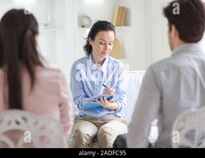 Thérapeute familial en prenant des notes lors de la consultation de couple
