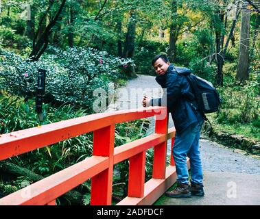 Un homme meilleur à beau paysage avec pont rouge du Japon à l'automne. Banque D'Images