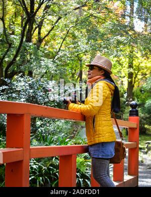 Woman traveler à beau paysage avec pont rouge du Japon à l'automne. Banque D'Images