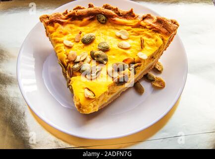 Morceau de tarte à la citrouille sur plaque blanche dans la lumière du soleil, repas de Thanksgiving Banque D'Images