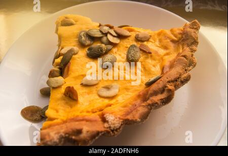 Morceau de tarte à la citrouille sur plaque blanche dans la lumière du soleil, repas de Thanksgiving Banque D'Images