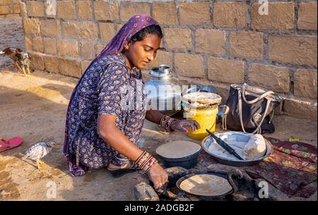 Jeune femme préparant chapati à l'extérieur, désert de Thar, Rajasthan, Inde Banque D'Images