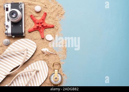 Vacances d'arrière-plan avec copie espace. Mer transport télévision lay. Accessoires de plage et d'une boussole sur le sable. Banque D'Images