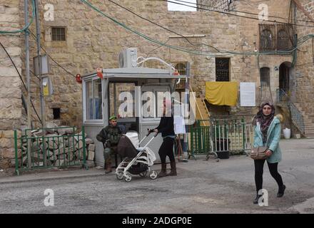 Un soldat israélien surveille une femme palestinienne et d'un colon juif pousser son bébé sur la rue Shuhada près du Tombeau des Patriarches, ou de la mosquée, dans la ville divisée de Hébron, en Cisjordanie, le Mercredi, Décembre 4, 2019. Le Ministre israélien de la Défense, Naftali Bennett a ordonné aux fonctionnaires de commencer à planifier une nouvelle colonie juive au coeur d'Hébron, dont les responsables palestiniens dire, c'est la suite de Le président américain Donald Trump a décidé de légitimer les colonies. Photo par Debbie Hill/UPI Banque D'Images