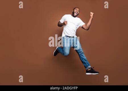 Toute la longueur de la taille du corps photo de joyeux fou excité positive de joie extatique se réjouir d'avoir acheté l'homme nouveau denim Jeans Prix réduit Banque D'Images