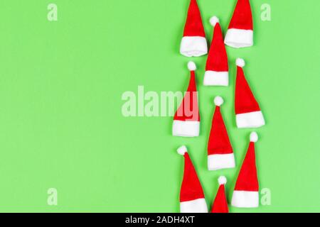 Vue de dessus od rouge élégant Santa hats sur fond coloré. Joyeux Noël concept avec copie espace. Banque D'Images