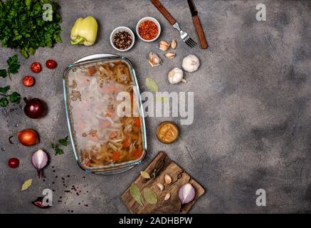 Jelly fait maison avec de la viande. L'Aspic de volaille et de boeuf, plat traditionnel russe et ukrainien sur un fond gris avec la moutarde. Copy space Banque D'Images