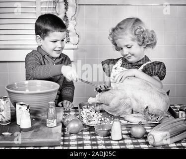 1950 SMILING BOY AND GIRL Frère et soeur plus âgée louche farce au pain en dinde de Thanksgiving SUR TABLE DE CUISINE - f4904 HAR001 HARS CÉLÉBRATION DE VIE FEMMES BROTHERS STUDIO SHOT ACCUEIL PRÉPARATION DE LA VIE PRENDRE SOIN DE MI-LONGUEUR Hommes frères soeurs CONFIANCE B&W SUCCÈS LE BONHEUR ET L'excitation de l'AVENTURE EN PROGRÈS SUR LA LIAISON FRÈRES MINEURS COOPÉRATION ÉLÉGANT CONCEPTUEL LOUCHE L'UNITÉ NOIR ET BLANC DE L'ORIGINE ETHNIQUE CAUCASIENNE HAR001 old fashioned Banque D'Images