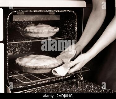 1930 WOMAN'S HANDS EN TENANT DEUX TARTES FAITS MAISON DU FOUR - f8422 HAR001 FEMME AU FOYER FEMME AU FOYER DU HARS HIGH ANGLE PRODUITS DE BOULANGERIE tartes ménagères FIERTÉ PÊCHE CRÉATIVITÉ MID-ADULT MID-ADULT WOMAN NOIR ET BLANC DE L'ORIGINE ETHNIQUE CAUCASIENNE LA PRÉPARATION DES ALIMENTS SEULEMENT LES MAINS HAR001 old fashioned Banque D'Images