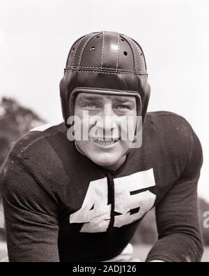 1940 JEUNE HOMME JOUEUR DE FOOTBALL PORTANT CASQUE DE PROTECTION EN CUIR grincer des dents dans l'expression menaçante LOOKING AT CAMERA - f9615 HAR001 CONCOURS D'ÉQUIPE DE SÉCURITÉ DE LA STATION DE RECHERCHE DE LA JOIE DE L'athlète d'emploi VIE DES PERSONNES DE LA SANTÉ PROFESSION ATHLÉTIQUE RISQUE MÂLES EXPRESSIONS CONFIANCE RUGUEUX B&W LES OBJECTIFS DE PROTECTION DE L'OCCUPATION COMPÉTENCES SUCCÈS AVENTURE COMPÉTENCES STRATÉGIE DE PROTECTION COURAGE CARRIÈRES CHOIX EXCITATION PUISSANTE DIRECTION DIRECTION DES LOISIRS LA FIERTÉ DE POUVOIR SE SENTIR ÉLÉGANT OCCASION PROFESSIONS AGRESSIF ÉMOTION ÉMOTIONS émotionnelle qui menace le sablage des JEUNES HOMMES ADULTES Banque D'Images