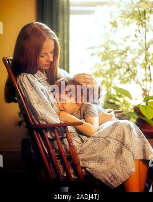 1970 Femme assise dans un rocking-chair confortable tout-petit garçon debout à côté d'ELLE EN PLANTE REMPLI FENÊTRE - kj7088 PHT001 HARS COMMUNICATION juvénile l'ÉQUILIBRE ENTRE LA SÉCURITÉ DES JEUNES ADULTES FORTE BASCULE FILS FAMILLE JOIE SATISFACTION DE VIE RURALE VIE FEMELLES PARENTALES ACCUEIL ESPACE COPIE mi-longueur amitié MESDAMES PERSONNES INSPIRATION SOINS HOMMES PROCHAINE CONSOLE CONFORT PROTECTION BONHEUR AIMANTES DE FLOU SUPPORT ÉLÉGANT GARÇON BÉBÉ CALME AFFECTION ATTACHEMENT PERSONNEL rempli d'ÉMOTION COOPÉRATION PLANTE CROISSANCE JUVÉNILES MAMANS ENTRETENIR SOLACE APAISER TOGETHERNESS WOMAN Banque D'Images