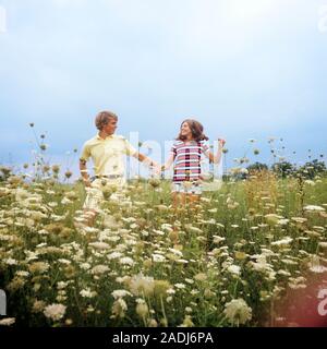 1970 TEENAGE COUPLE HOLDING HANDS QUI TRAVERSE UN CHAMP DE QUEEN ANNE'S LACE SMILING PORTANT DES VÊTEMENTS D'ÉTÉ - KS7449 HAR001 HARS VIEILLE nostalgie de temps à l'ancienne équipe juvénile SHORT STRONG HEUREUX JOIE SATISFACTION DE VIE SANTÉ EN MILIEU RURAL LES FEMMES CÉLÉBRATION NATURE COPIE Espace demi-longueur d'AMITIÉ LES PERSONNES QUI S'OCCUPENT LES HOMMES TEENAGE GIRL BOY STRIPES ÉTÉ DATING BONHEUR CONFIANCE RÊVES AVENTURE EXCITATION LOISIRS LOISIRS ANGLE FAIBLE CONNEXION SOURIRES ATTRACTION FLOU FRÉQUENTATIONS ADOLESCENTES ÉLÉGANT JOYEUSE ANNE'S ATTACHEMENT PERSONNEL POSSIBILITÉ DE COOPÉRATION DE L'AFFECTION Banque D'Images