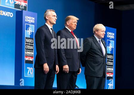 Watford, Royaume-Uni. 04 Décembre, 2019. Le Président américain Donald Trump, centre, s'élève avec le Secrétaire général de l'OTAN, M. Jens Stoltenberg, gauche et d'accueillir le Premier ministre britannique Boris Johnson au début du sommet de l'OTAN le 4 décembre 2019 à Watford, Hertfordshire, Royaume-Uni. La réunion marque le 70e anniversaire de l'Organisation du Traité de l'Atlantique Nord traité. Credit : Shealah Planetpix Craighead//Alamy Live News Banque D'Images