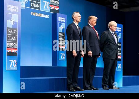 Watford, Royaume-Uni. 04 Décembre, 2019. Le Président américain Donald Trump, centre, s'élève avec le Secrétaire général de l'OTAN, M. Jens Stoltenberg, gauche et d'accueillir le Premier ministre britannique Boris Johnson au début du sommet de l'OTAN le 4 décembre 2019 à Watford, Hertfordshire, Royaume-Uni. La réunion marque le 70e anniversaire de l'Organisation du Traité de l'Atlantique Nord traité. Credit : Shealah Planetpix Craighead//Alamy Live News Banque D'Images