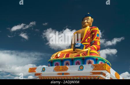 Grande statue de Bouddha coloré contre un brillant ciel bleu et nuages blancs en été le 17 septembre 2019 à Langza, Himachal Pradesh, Inde. Banque D'Images