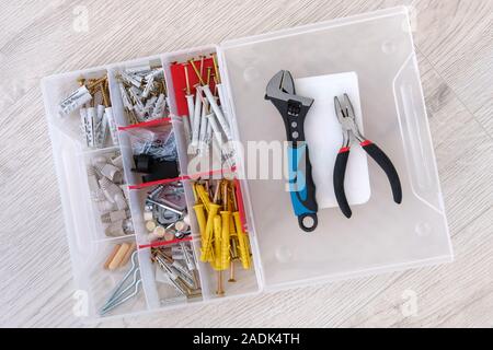 Fort à l'aide d'outils spéciaux, de pièces, d'une pince et clé à molette, libre. Outils sur fond de bois clair. Réparation de bricolage. Vue d'en haut. Banque D'Images