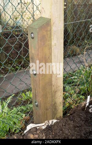 Un poteau de clôture cassée pourris et réparé par l'ajout d'un épi en bois à l'aide de vis à tête carrée, England, UK Banque D'Images