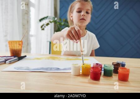 A la peinture. Petite fille n'est à l'aide de la gouache et un pinceau. L'apprentissage dans la classe d'art Banque D'Images