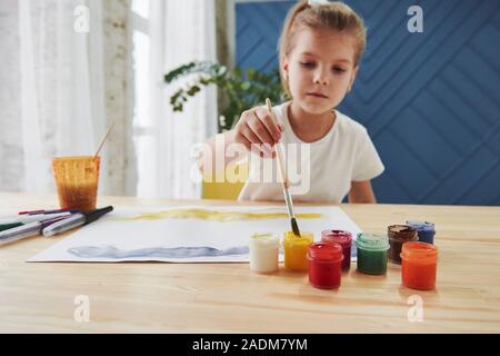 Petite fille n'est à l'aide de la gouache et un pinceau. L'apprentissage dans la classe d'art Banque D'Images