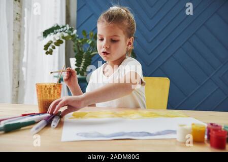 En tenant le marqueur. Petite fille n'est à l'aide de la gouache et un pinceau. L'apprentissage dans la classe d'art Banque D'Images