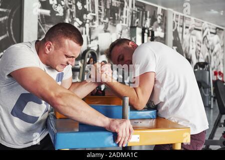 Face à l'expression. Arm wrestling challenge entre deux hommes. Correspondance sur un tableau spécial Banque D'Images