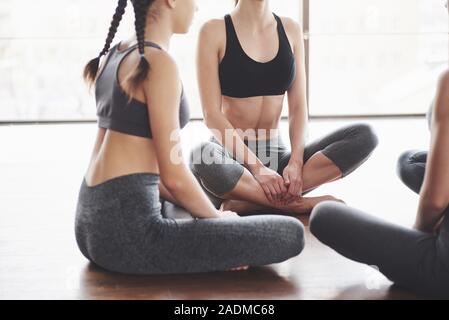 Photo recadrée. Processus d'enseignement pour une remise en forme. Trois femmes s'assoit et à la recherche d'un formateur Banque D'Images