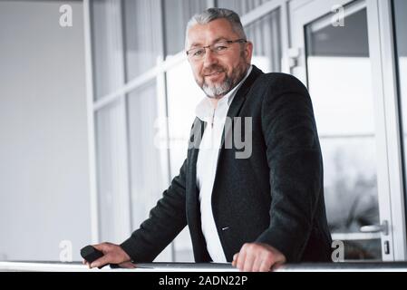 Personne agréable. Photo de senior businessman dans le grand prix. Holding phone and smiling Banque D'Images