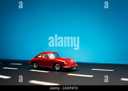 Izmir, Turquie - le 28 juillet 2019. Vue latérale d'une Porsche Carrera 2 modèle jouet voiture sur un fond bleu. Banque D'Images