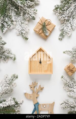 Noël et Nouvel An toujours la vie. Horloge en bois montre cinq minutes avant minuit. Branches de sapin et les boîtes autour. Banque D'Images