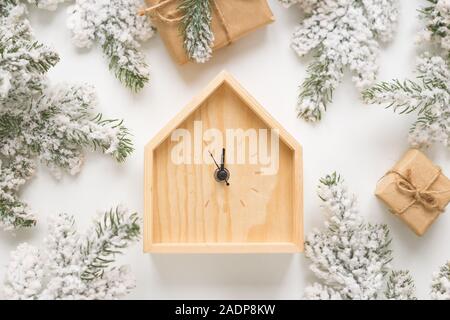 Noël et Nouvel An toujours la vie. Horloge en bois montre cinq minutes avant minuit. Branches de sapin et les boîtes autour. Vue de dessus Banque D'Images