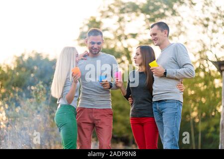 Pique-nique avec des amis par l'incendie. Les amis de l'entreprise ayant un pique-nique Randonnée nature background. Les amis de raconter des histoires. Pique-nique d'été. S'amuser avec des amis. Banque D'Images