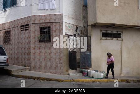 Caracas, Venezuela, Miranda. 29 Nov, 2019. L'eau de remplissage aura contaners avec l'eau de la maison de sa sœur.Aura Graciela Sarmiento, l'âge de 56 ans, et son mari Jose Alberto Abreu, 62 ans, n'ont pas eu l'eau courante dans leur maison en 4 ans. Aura travaille dans un magasin de vente de mobilier de bureau, et Jose est un mécanicien. Ils vivent dans le quartier d'Altos de Lidice à Caracas au Venezuela. Altos de Lidice est un quartier historique Chavista. Cependant, l'Aura est pro-opposition, et n'a jamais appuyé le régime de Chavez, même si elle a vécu dans ce pro-Chavez/Maduro barrio toute sa vie. S Banque D'Images