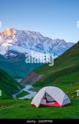 La tente à la tête de la gorge en face d'Enguri Shkhara peak, le plus haut point de la Géorgie. Ushguli, Samegrelo-Zemo Svaneti, région de la Géorgie. Banque D'Images