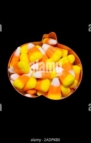 Bonbons d'Halloween en forme de citrouille de maïs à l'intérieur d'une pâte à l'emporte-pièce sur un fond noir. Banque D'Images