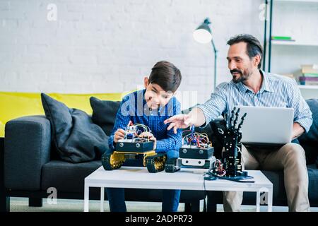 Homme serviable aider son fils avec l'ingénierie robotique Banque D'Images