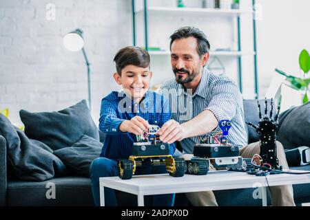 Heureux père d'aider son fils avec la construction du robot Banque D'Images