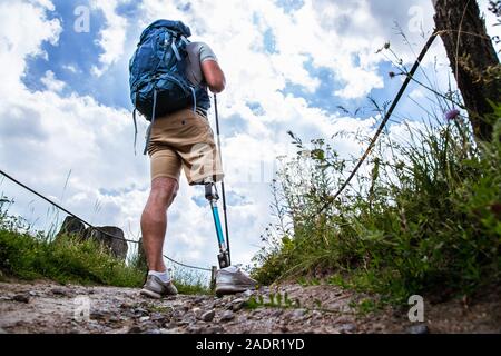 Vue arrière d'un jeune homme sportif avec une prothèse debout sur le chemin Banque D'Images