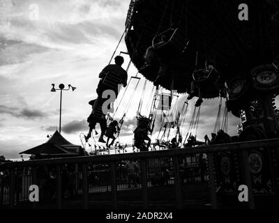 Silhouette sur un ciel de l'automne jouissent d'une ride à la county fair. Banque D'Images