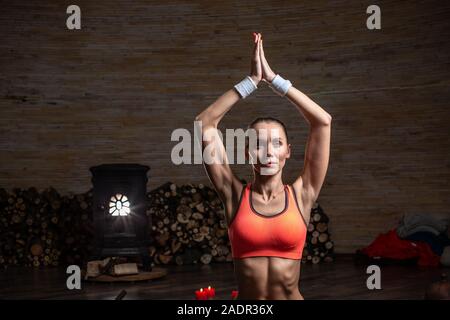 Taille de slim femme assise en yoga pose avec les mains au-dessus de la tête Banque D'Images