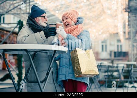 Couple excité qui retentit de tasses de café au cours de la réunion Banque D'Images