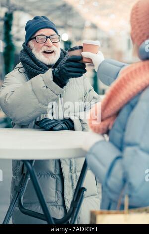 Ravis man putting carton tasse de café pendant que qui retentit Banque D'Images