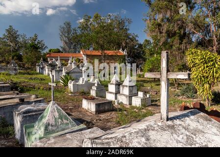 Vue de style byzantin des pierres tombales blanches sur Cemetery à côté de la vieille église coloniale historique de petit village rural, Chapada Diamantina, Bahia, Br Banque D'Images