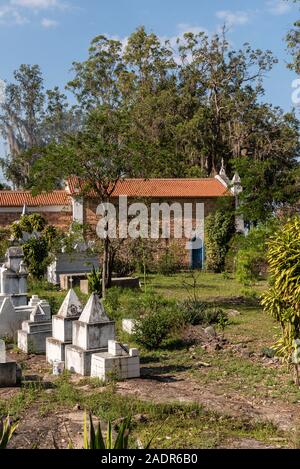 Vue de style byzantin des pierres tombales blanches sur Cemetery à côté de la vieille église coloniale historique de petit village rural, Chapada Diamantina, Bahia, Br Banque D'Images